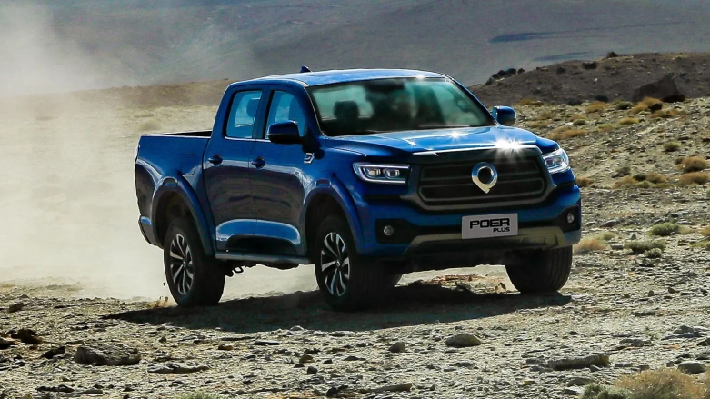 Camioneta pick up Nueva Poer Automática GWM color azul siendo conducida por terreno rocoso.
