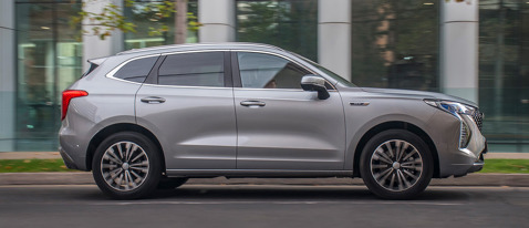 Vista lateral de Haval Jolion HEV hibrido gris en la ciudad