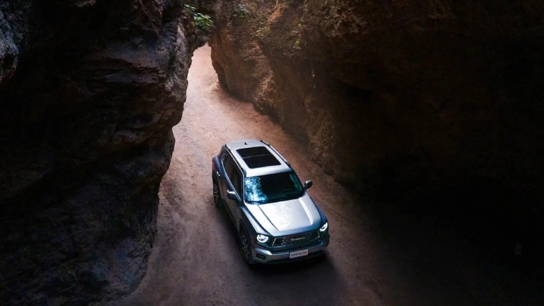 SUV 4x4 Haval H7 color gris visto desde la parte de arriba siendo conducido entre rocas.